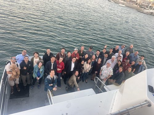 A group of people standing on a boat and smiling at the camera.